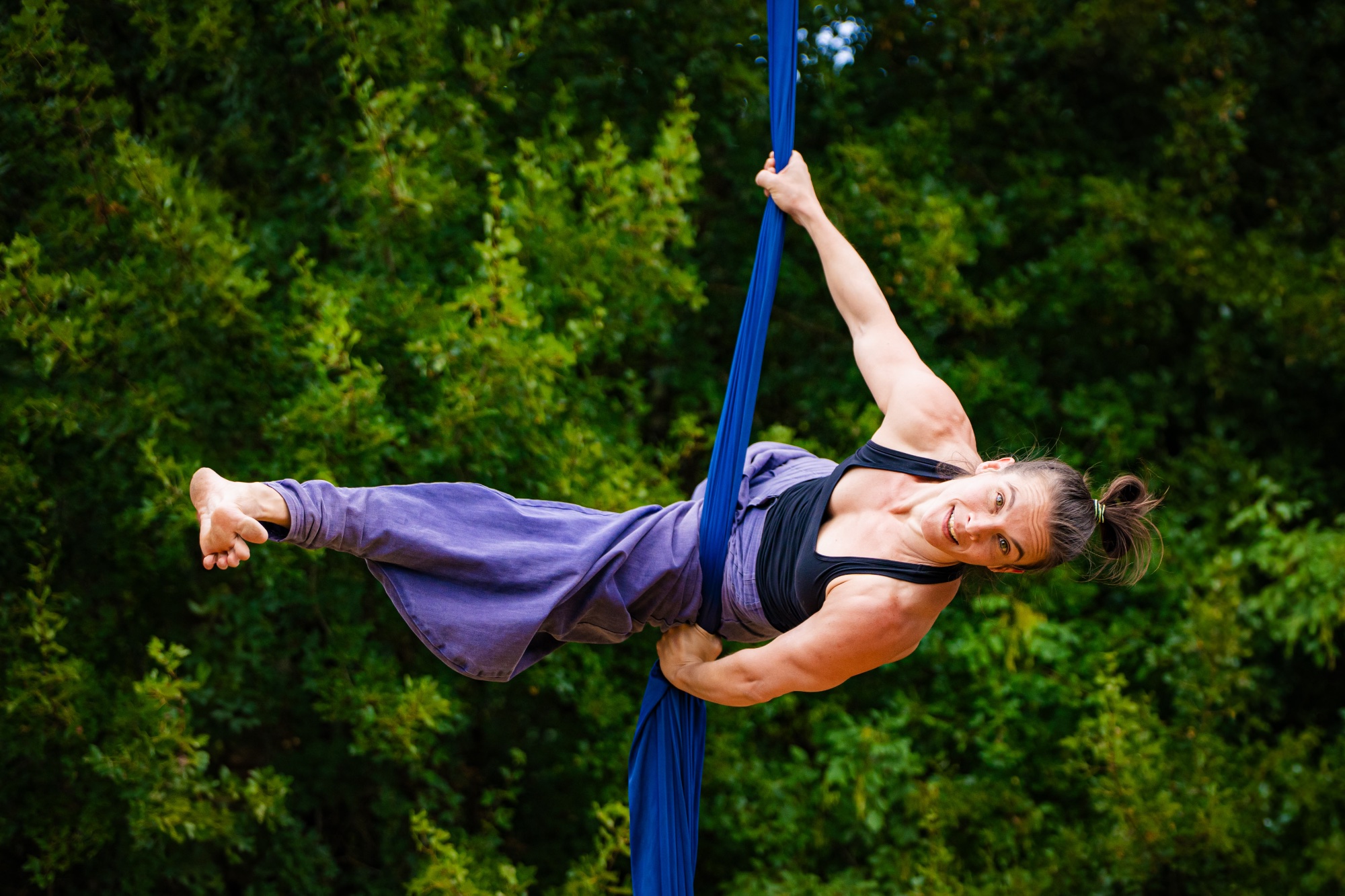 Aerial silks hanging on an open deck above the sea at sunrise